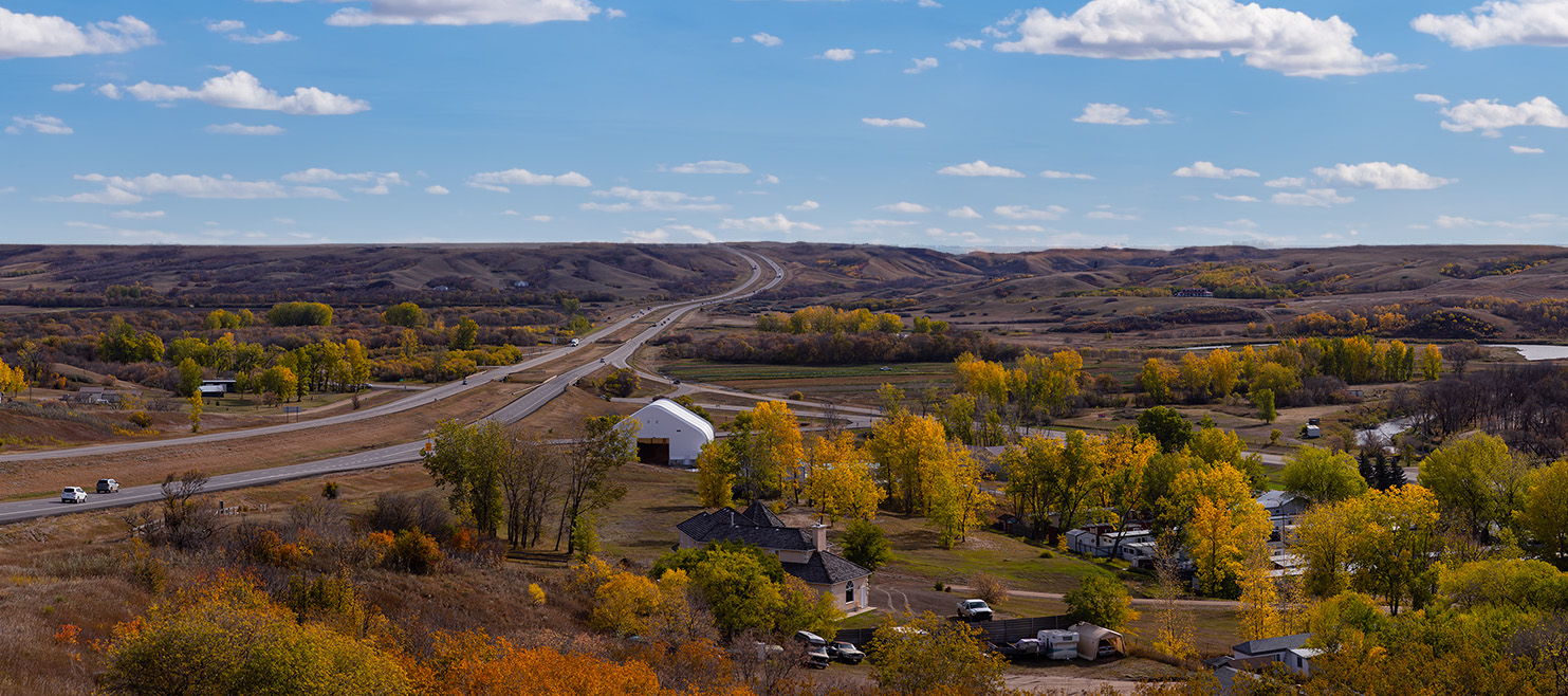 Aerial Panoramic view of a small Town in the Prairies during a vibrant sunny day in the Fall Season. Taken in Lumsden, Saskatchewan, Canada